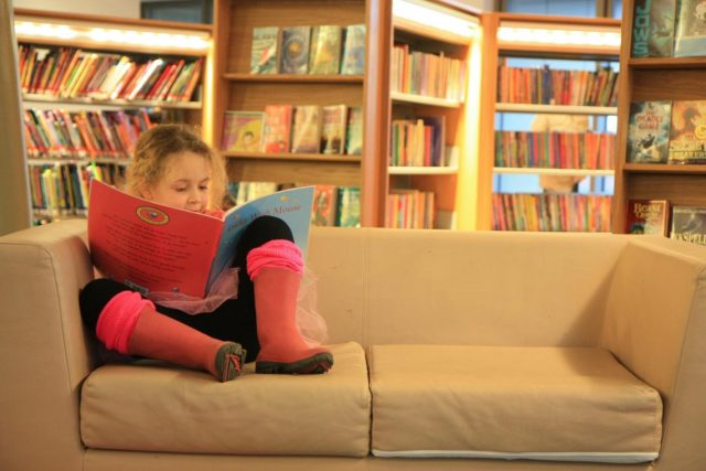 kid is reading in a library